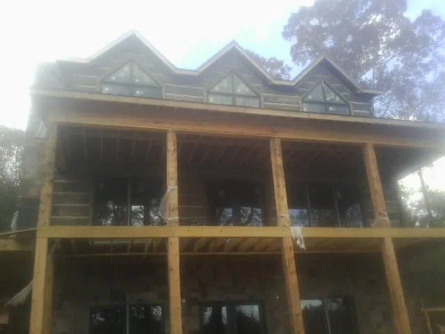 Dormers and porch framing on a large log home under construction — Roof Coating work by our crew in Butler